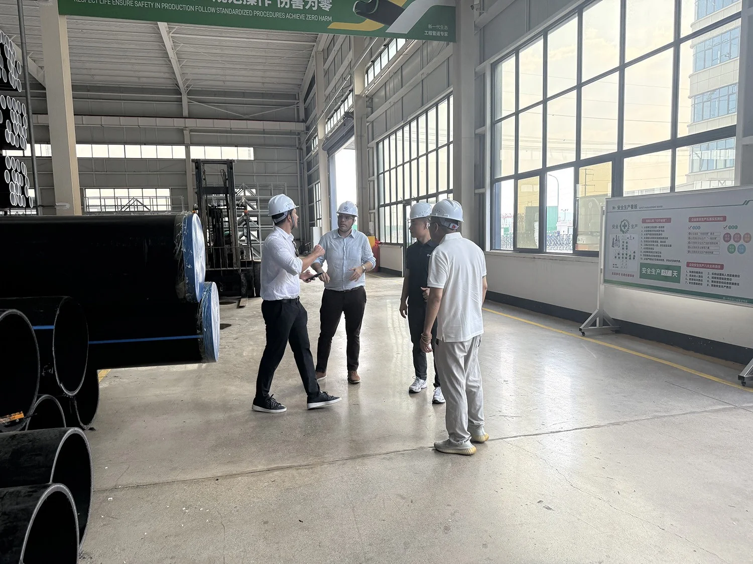 SIFFO representatives discussing HDPE pipe quality requirements with two Spanish customers in the production workshop